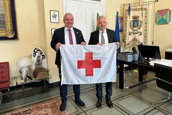 La bandiera e le luci di colore rosso sul Palazzo Civico della Spezia per ringraziare la Croce Rossa